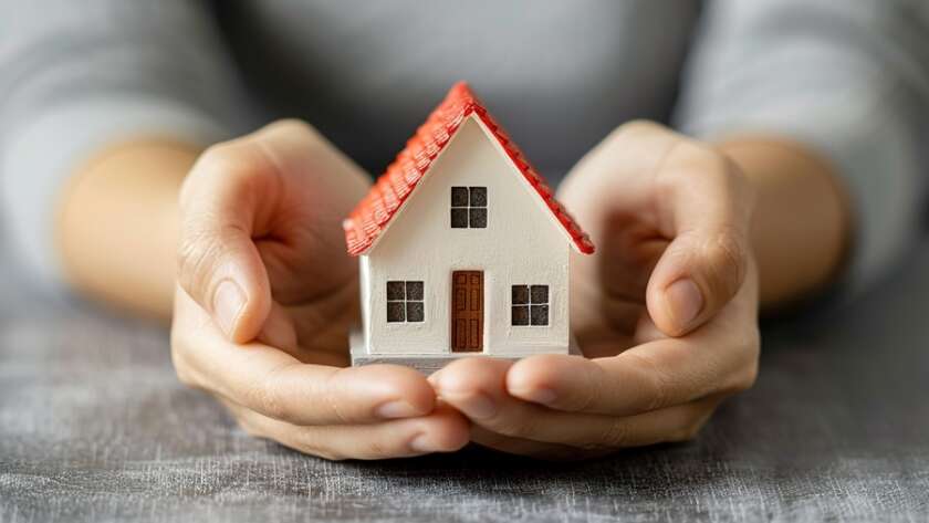 Hands Protecting Miniature House Model - home insurance